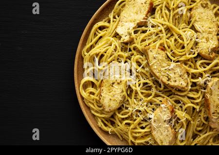 Pesto alla Genovese fatto in casa Pasta su un piatto su sfondo nero, vista dall'alto. Giacitura piana, sovratesta, dall'alto. Spazio di copia. Foto Stock