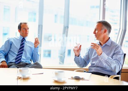 Dirigenti che hanno conversazione al tavolo. Partner commerciali che discutano del caffè. Foto Stock