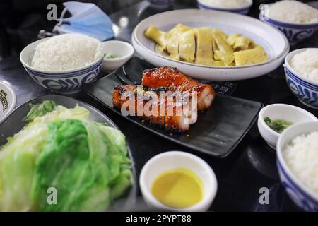 Una varieta' di piatti Asiatici e riso bianco serviti su un tavolo in una presentazione in stile buffet Foto Stock