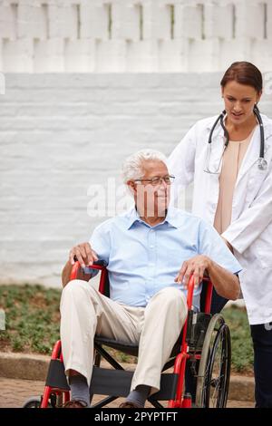 Dove vuoi andare. una dottoressa che spinge la paziente anziana su una sedia a rotelle all'esterno. Foto Stock
