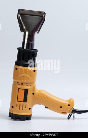 Pistola termica gialla con testa in metallo isolata su sfondo studio Foto Stock