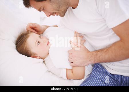 L'ultima faccia che vede prima che lei derivi... Un papà che dice la buonanotte a sua figlia. Foto Stock