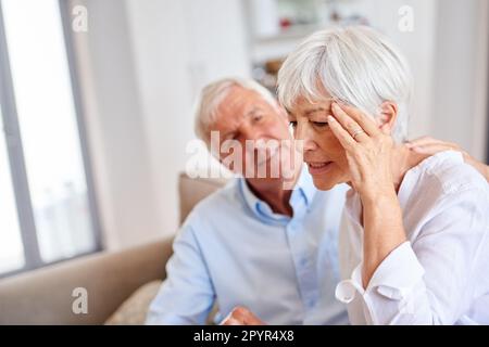 Siediti e lasciami prendere cura di te. un uomo anziano che consolava la moglie. Foto Stock