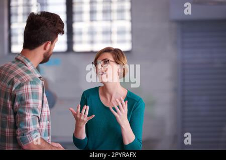 Il lavoro di squadra fa funzionare il sogno. Un gruppo di giovani creativi che parlano intorno ad un tavolo. Foto Stock
