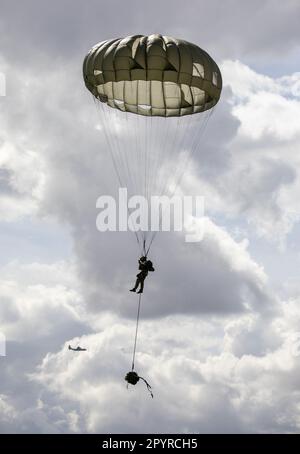 Un paracadutista assegnato agli Stati Uniti Special Operations Command Europe scende in una zona di caduta vicino ad Alzey, Germania durante un salto di formazione statico, 14 aprile 2023. I Paratroopers conducono regolarmente una formazione multinazionale Airborne per garantire la padronanza continua delle loro abilità e abilità. Questo tipo di formazione garantisce che SOCEUR sia presente, letale e pronto a essere utilizzato rapidamente in qualsiasi luogo e in qualsiasi momento. (STATI UNITI Foto dell'esercito di Sgt. Laura Bauer) Foto Stock