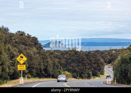 Taupo, Nuova Zelanda - 25 ottobre 2022: Auto che viaggiano lungo la Volcanic Loop Highway con Motutaiko Island chiaramente visibile nel mezzo, che sorge o Foto Stock