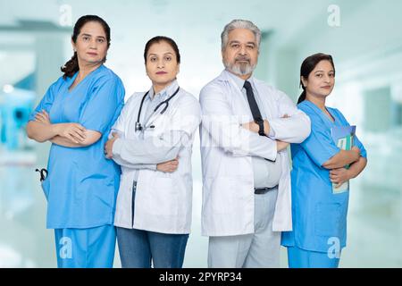 Gruppo di medici indiani maschi e femmine fiduciosi e personale infermieristico con stetoscopio in piedi a braccia incrociate guardando la macchina fotografica, concetto di assistenza sanitaria. Foto Stock