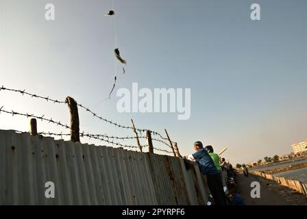 Pescatori ricreativi in piedi su motociclette per pescare su uno stagno situato in un'area chiusa nella zona costiera di Giacarta nel villaggio di Marunda, Cilincing, North Jakarta, Jakarta, Indonesia. Foto Stock