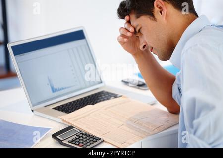 Il successo non è possibile senza un duro lavoro. un giovane dirigente frustrato che guarda stressato mentre fa il suo lavoro di ufficio. Foto Stock