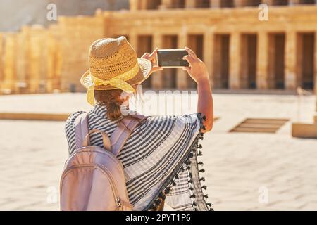Donna turistica scattando foto delle rovine Tempio mortuario di Hatshepsut Foto Stock