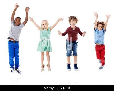 Felice, saltando e ritratto di bambini in studio per la diversità, gli amici e il gioco. Felicità, gioventù e sorriso con gruppo di bambini isolati su bianco Foto Stock