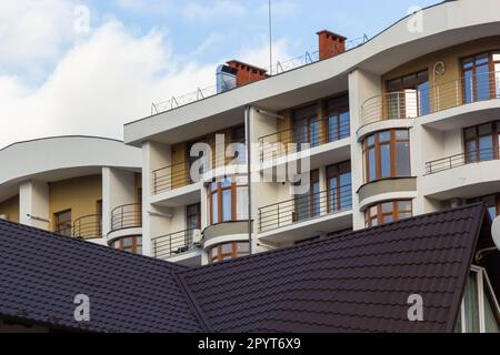 Dettagli architettonici di alto edificio moderno con molte finestre e balconi. Foto Stock