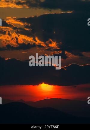 Strati di cielo spettacolare al tramonto sulle montagne. Foto Stock