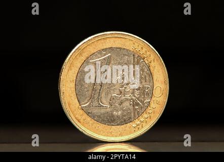 Una moneta da un euro molto usata su sfondo nero Foto Stock