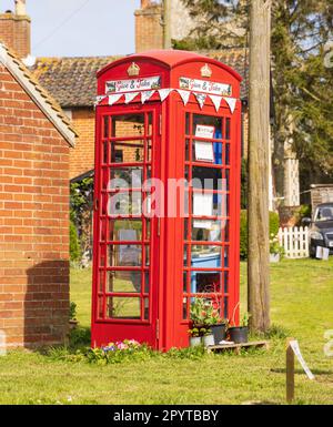 Vecchia cassetta telefonica rossa pubblica utilizzata come hub per scambiare liberamente libri, cibo, piante e giocattoli indesiderati. Middleton, Suffolk, Regno Unito Foto Stock