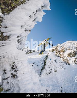 Escursionista con sci sale attraverso ghiaccio nevoso e rocce a Katahdin, Maine Foto Stock