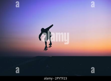 Skateboarder in azione, silhouette irriconoscibile. Foto Stock