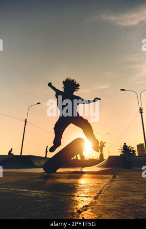 Skateboarder in azione. Ragazzo facendo skate trucco aria con presa Foto Stock