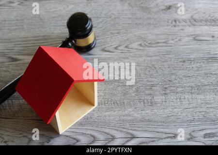 Casa giocattolo e giudice Gavel su tavolo di legno con spazio copia. Diritto immobiliare e concetto di casa d'asta Foto Stock