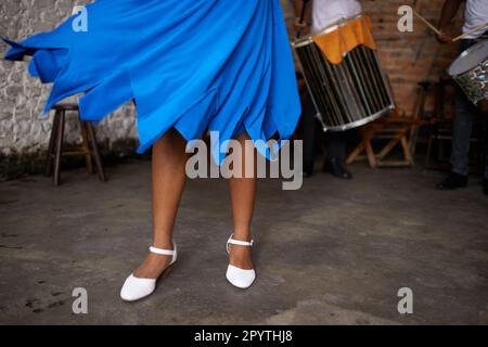 blu abito canzone. una donna con gonna blu che balla sul palco con una band sullo sfondo. Foto Stock