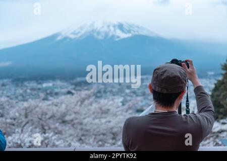 Fotografo maschile che scatta una foto di Mt. Fuji, vista da dietro Foto Stock