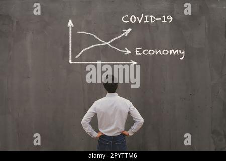 Concetto di crisi econimica dovuta al coronavirus COVID-19 diffuso nel mondo, virus curva in alto, economia in basso Foto Stock