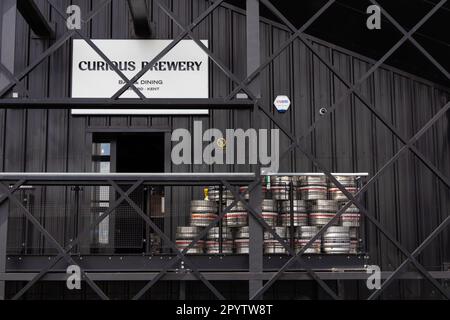 Vista laterale del bar Curious Brewery e dell'ingresso per la cena con botti di birra in metallo, ashford, kent, regno unito Foto Stock