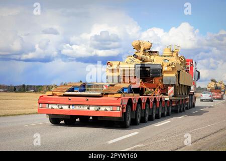 Eccezionale trasporto di carichi del carro armato militare M1 Abrams dell'esercito degli Stati Uniti nel traffico. Convoglio di tre trasporti cisterna. Aura, Finlandia. Aprile 28, 2023. Foto Stock