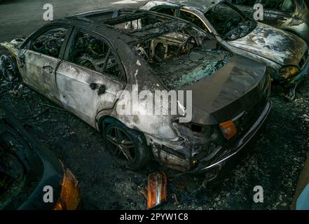 automobili dopo il fuoco. Due auto bruciate con cofano aperto. Arson, auto bruciata Foto Stock