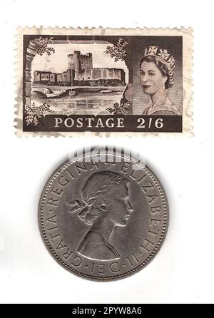 Moneta a mezza corona e francobollo del regno della regina Elisabetta II isolato su sfondo bianco. Foto Stock