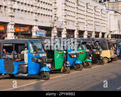 Una fila di tuc parcheggiati nella riserva centrale di Hospital Road nella città settentrionale di Jaffna, Sri Lanka Foto Stock