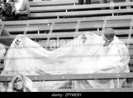 Coppa del mondo di Calcio 1974 2nd turno / BR Germania - Svezia 4:2 / 30.06.1974 a Duesseldorf / spettatori , i tifosi cercano rifugio dalla pioggia sotto un tarp o pioggia capes. [traduzione automatica] Foto Stock