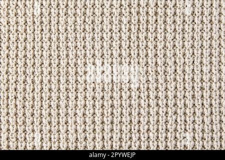 Frammento di abiti a maglia beige di maglia ruvida. Sfondo per il design, mock-up Foto Stock