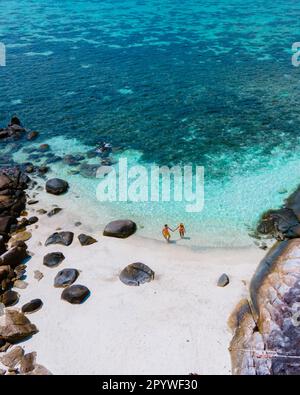 Isola di KLA Koh Lipe Thailandia è una piccola isola sulla costa di Ko Lipe con una barriera corallina e un grande luogo per lo snorkeling, coppia di uomini e donne sulla spiaggia visto da una vista drone Foto Stock