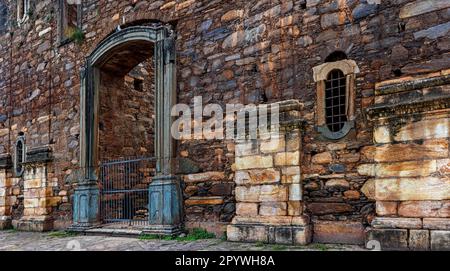 Mura di pietra forte di chiesa coloniale storica incompiuta in rovine nella città di Sabara in Minas Gerais, Brasile, Brasile Foto Stock