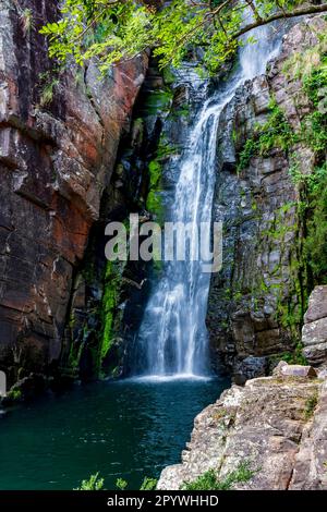Acque della cascata chiamata Veu da Noiva tra rocce ricoperte di muschio e la vegetazione di una zona con la natura conservata nello stato di Minas Gerais Foto Stock