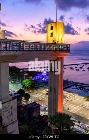 Facciata del famoso ascensore Lacerda illuminato di notte della città di Salvador in Bahia con il mare sullo sfondo, Brasile Foto Stock