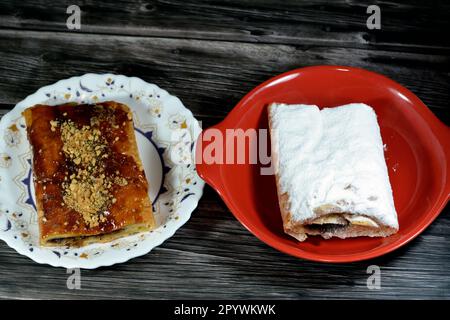 Torta di mele farcita con mela cremosa, cannella e sciroppo di miele dolce zuccherato e sormontata con pistacchi, noci e zucchero a velo, delizioso dolcificato al forno Foto Stock