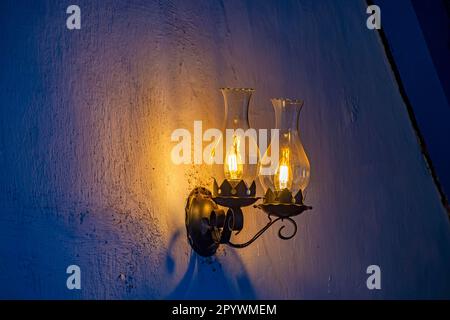 Vecchia lampada adattata per la luce elettrica su una parete rustica e rugosa, Lagoa Santa, Minas Gerais, Brasile Foto Stock