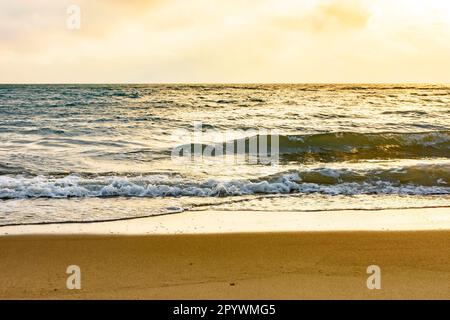Tramonto sul mare dell'isola di Ilhabela a San Paolo litoral con la spiaggia, le onde, l'oceano e l'orizzonte durante l'estate, Brasile Foto Stock