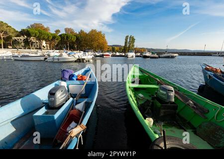 Pittoresco Lago Bolsena al tramonto: Serate tranquille a Bolsena con barche che si tuffano dolcemente sull'acqua calma mentre il tramonto dipinge il cielo con colori caldi Foto Stock