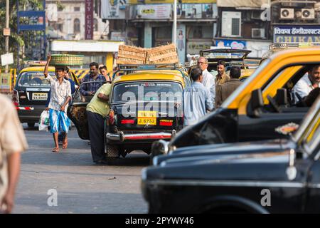 Vita urbana con taxi, vista della città dalle strade del quartiere dominato dai musulmani di Pydhonie, Mumbai, India Foto Stock
