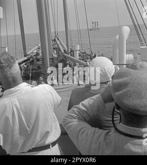 Persone a bordo di una nave in un viaggio in Brasile guardando in lontananza, all'orizzonte un'altra nave alta con vele issate sul mare aperto (colpo non effettuato). Foto Stock