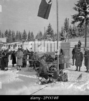 I funzionari si siedono al traguardo di una competizione di fondo e aspettano gli atleti. Le bandiere di piccole dimensioni sullo sfondo mostrano che questo concorso deve essere internazionale. Foto non datata, probabilmente nell'inverno del 1933/1934. Foto Stock