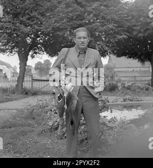 Un uomo ben vestito che posa con un'anatra a pallini davanti a uno stagno. È probabilmente un proprietario o un membro della famiglia nella provincia di Pomerania. Foto non datata, probabilmente negli anni '1930s. Foto Stock