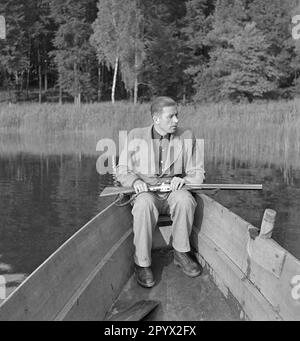 Un uomo ben vestito è seduto su una barca a remi con una pistola. Sta cacciando anatre. È probabilmente un membro di una proprietà nella provincia di Pomerania. Foto non datata, probabilmente negli anni '1930s. Foto Stock