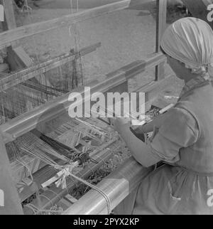 Una donna lavora su un telaio di moquette. Foto Stock