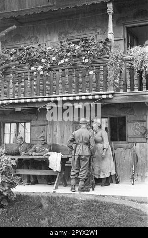 Durante un esercizio di un Gebirgsjaegerkompanie (compagnia di fanteria di montagna) sul Tegernsee: Soldati e la padrona di casa della fattoria dove sono squartati. Foto Stock