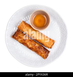 vista dall'alto di involtini primavera fritti vietnamiti di maiale farcito, carote, funghi, carta di riso, germogli di soia su piatto tagliato su sfondo bianco Foto Stock