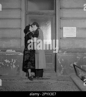 Un uomo e una donna flirta e bacia davanti ad una porta. Foto Stock
